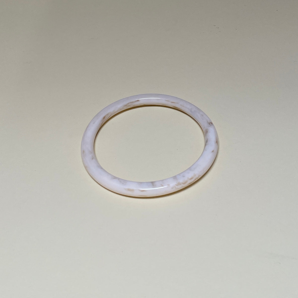 Rundt armbånd i cremehvid plast